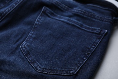 Photo of Jeans with pocket on grey background, closeup