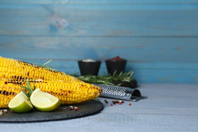 Photo of Tasty fried corn, spices and ingredients on light blue wooden table. Space for text