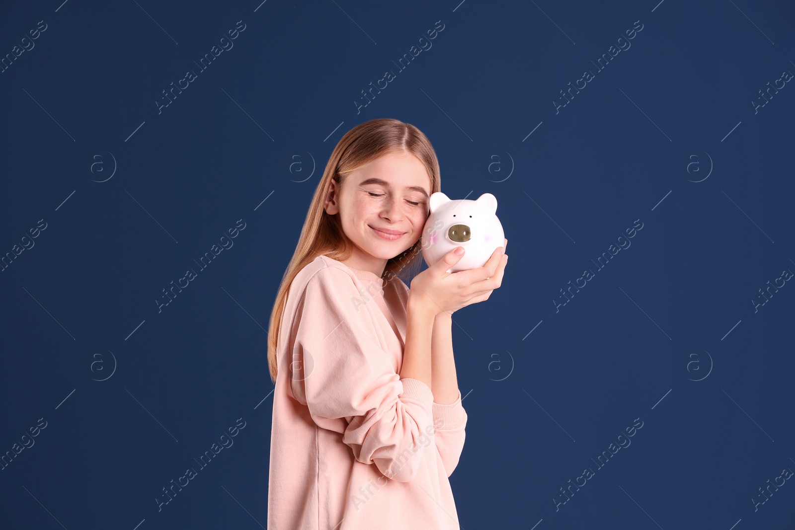 Photo of Teen girl with piggy bank on color background