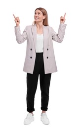 Beautiful happy businesswoman pointing at something on white background