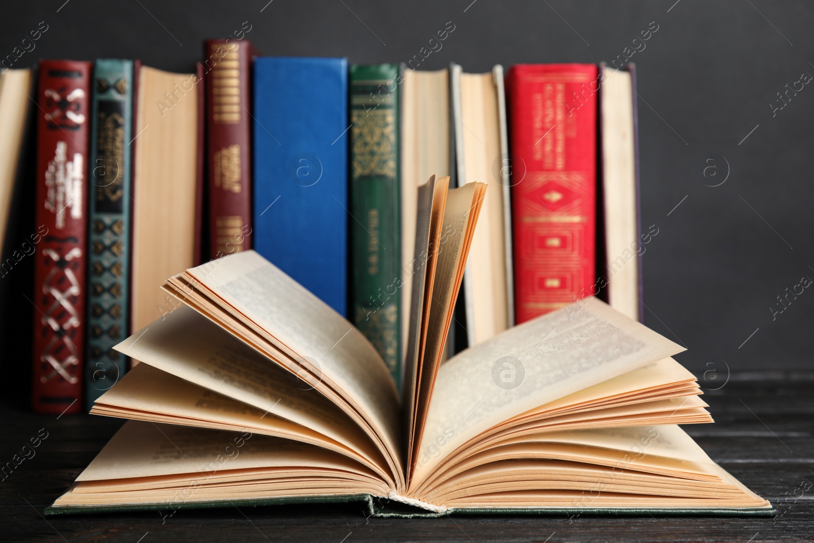 Photo of Open hardcover book on black wooden table