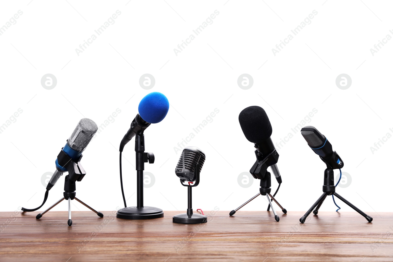 Photo of Set of different microphones on wooden table. Journalist's equipment