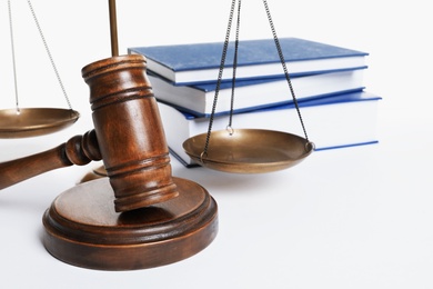 Wooden gavel, scales of justice and books on white background. Law concept