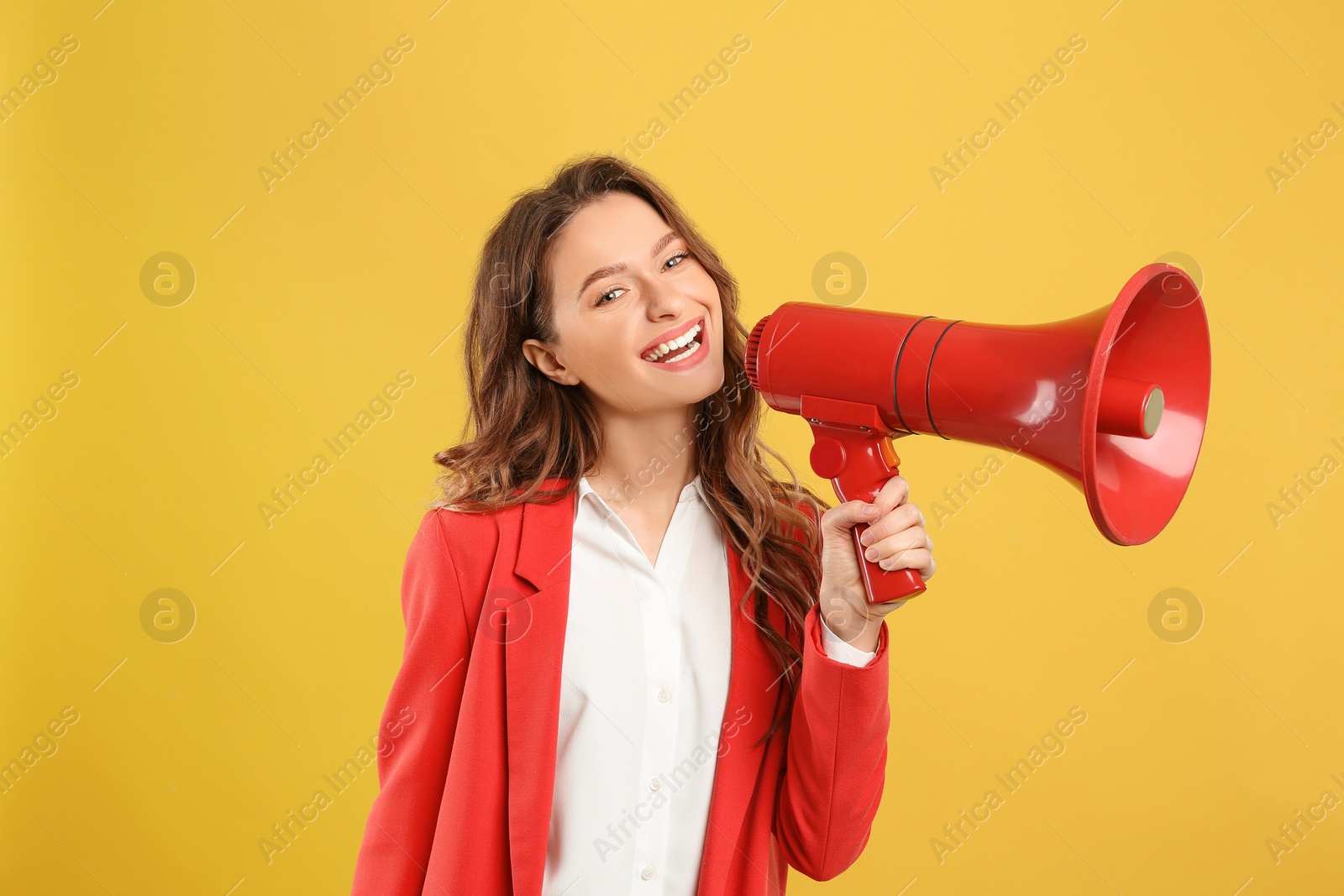 Photo of Young woman with megaphone on yellow background