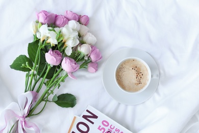 Flat lay composition with cup of coffee, beautiful flowers and magazine on fabric