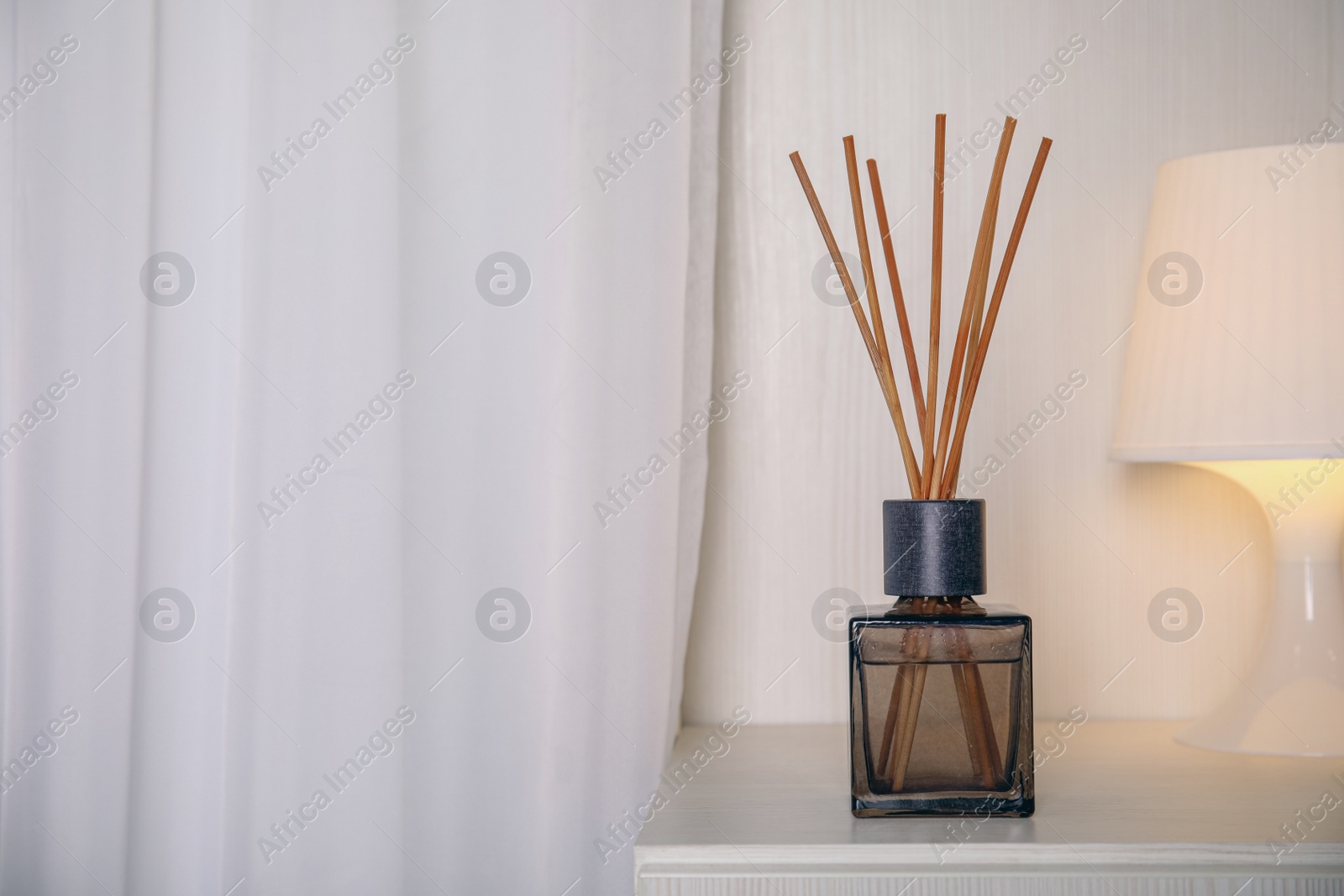 Photo of Aromatic reed freshener on bedside table indoors, space for text