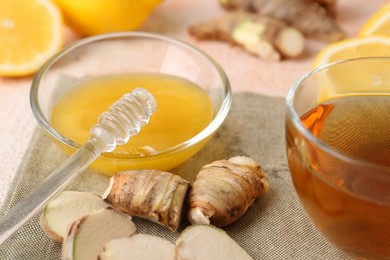 Photo of Tea, honey, lemon and ginger on grey table, closeup