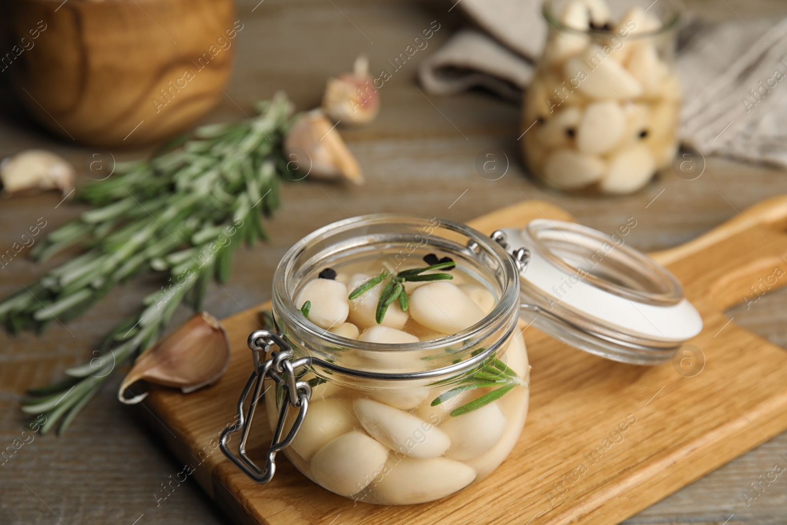 Photo of Composition with jar of pickled garlic on wooden table