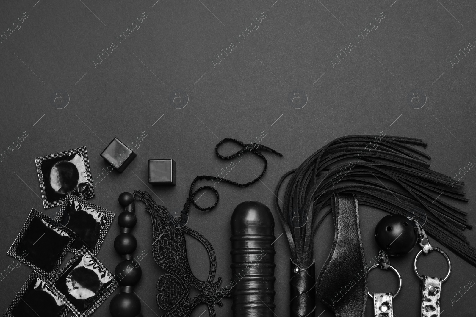 Photo of Different sex toys on black background, flat lay. Space for text