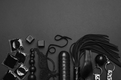 Photo of Different sex toys on black background, flat lay. Space for text