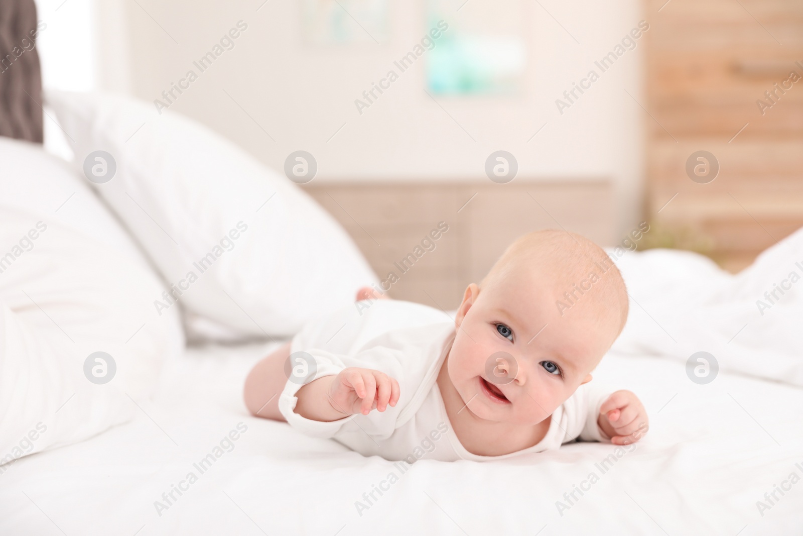 Photo of Cute little baby lying on bed at home