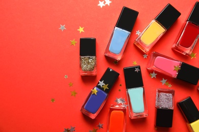 Bottles of nail polish on color background, top view with space for text