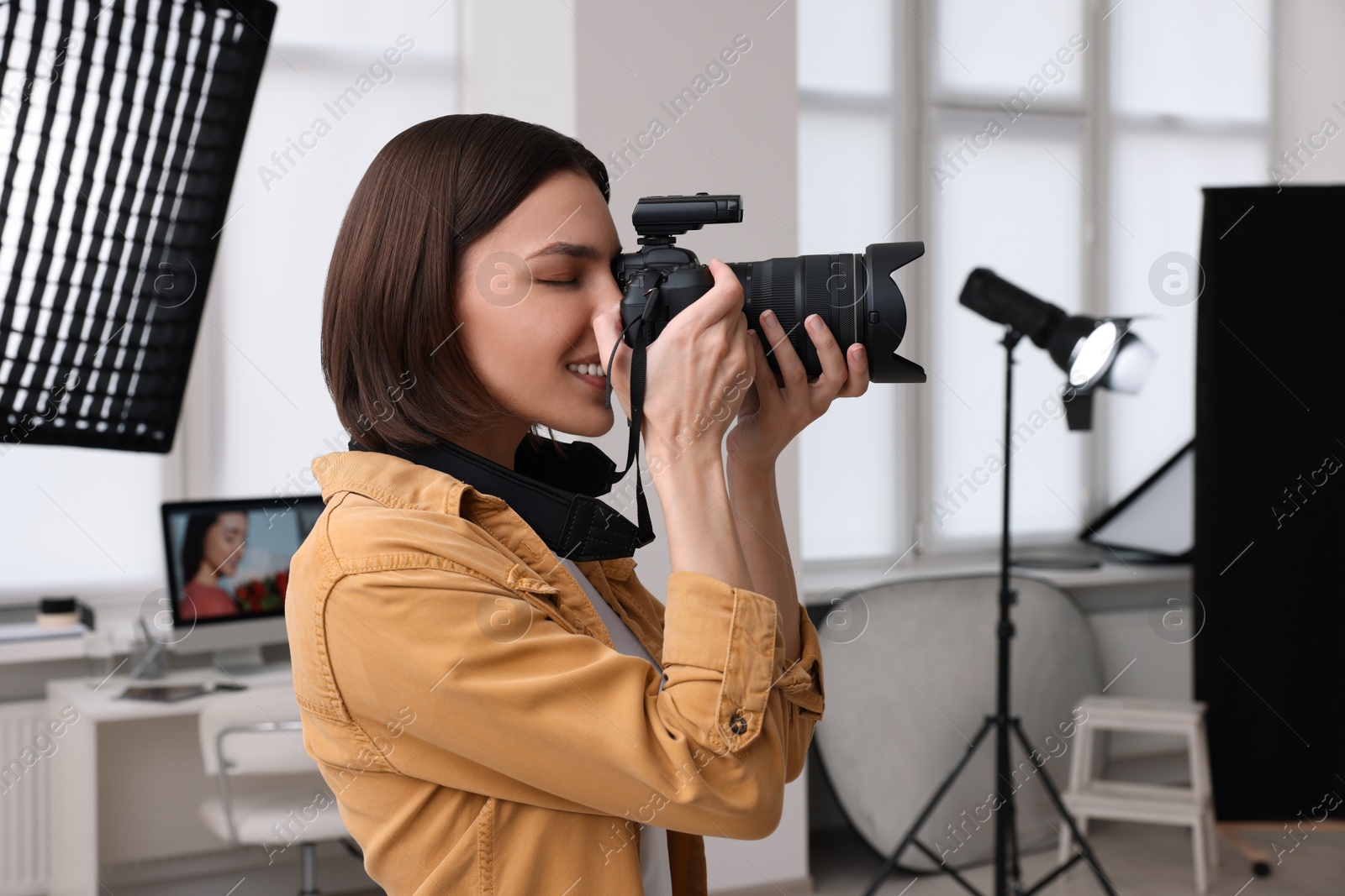 Photo of Professional photographer taking picture in modern photo studio