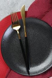 Clean plates, cutlery and napkin on table, top view