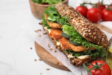 Photo of Delicious sandwich with schnitzel on white table, space for text