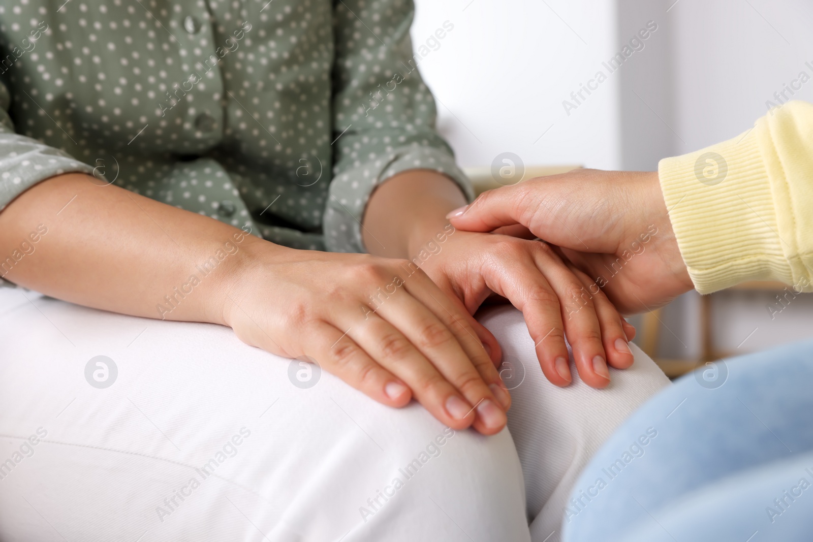 Photo of Psychotherapist holding patient's hand in office, closeup