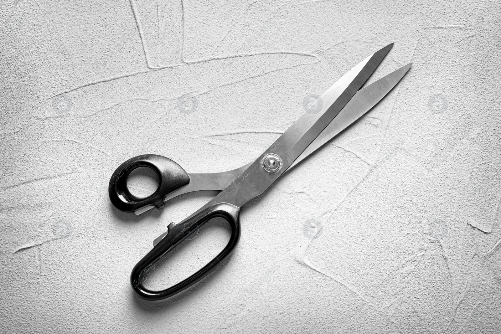 Photo of Scissors on light background, top view. Tailoring equipment