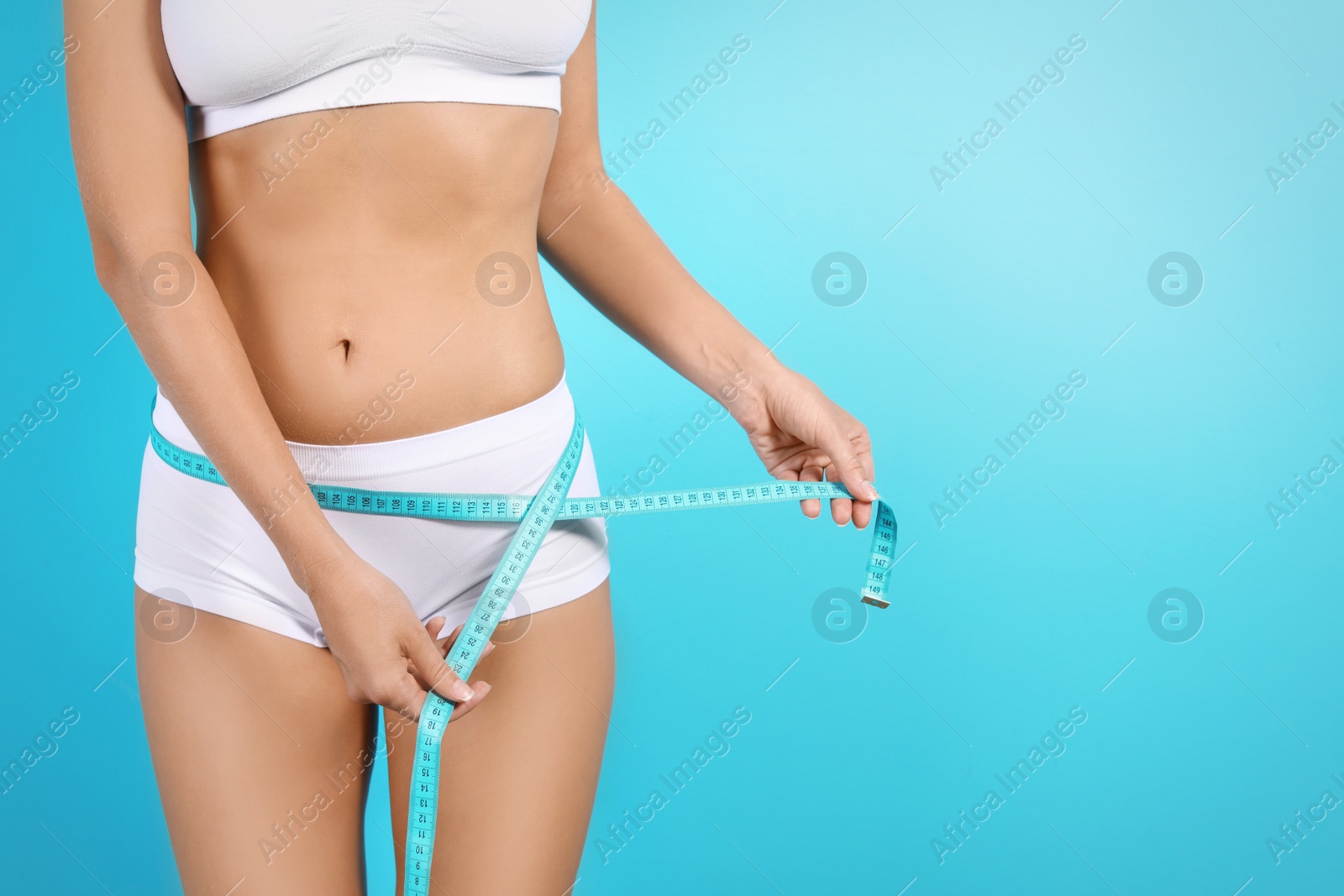 Photo of Slim woman with measuring tape on color background. Healthy diet