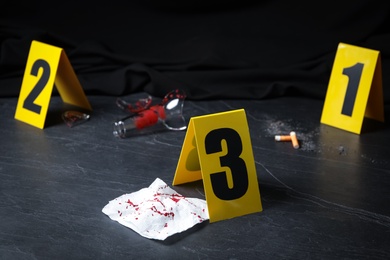 Photo of Bloody napkin and crime scene marker on black slate table