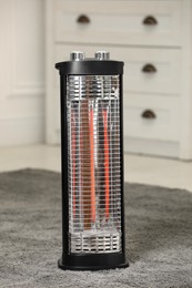 Modern infrared heater on carpet in room