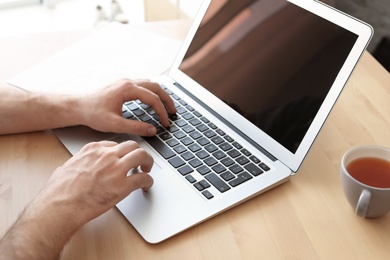 Young man working with laptop at desk. Home office