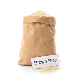 Photo of Paper bag with uncooked brown rice and card on white background