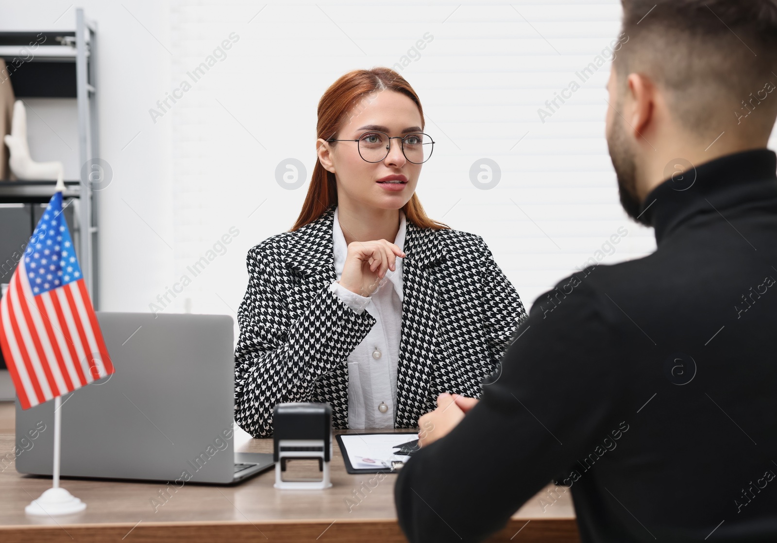 Photo of Embassy worker consulting man about immigration to United States of America in office