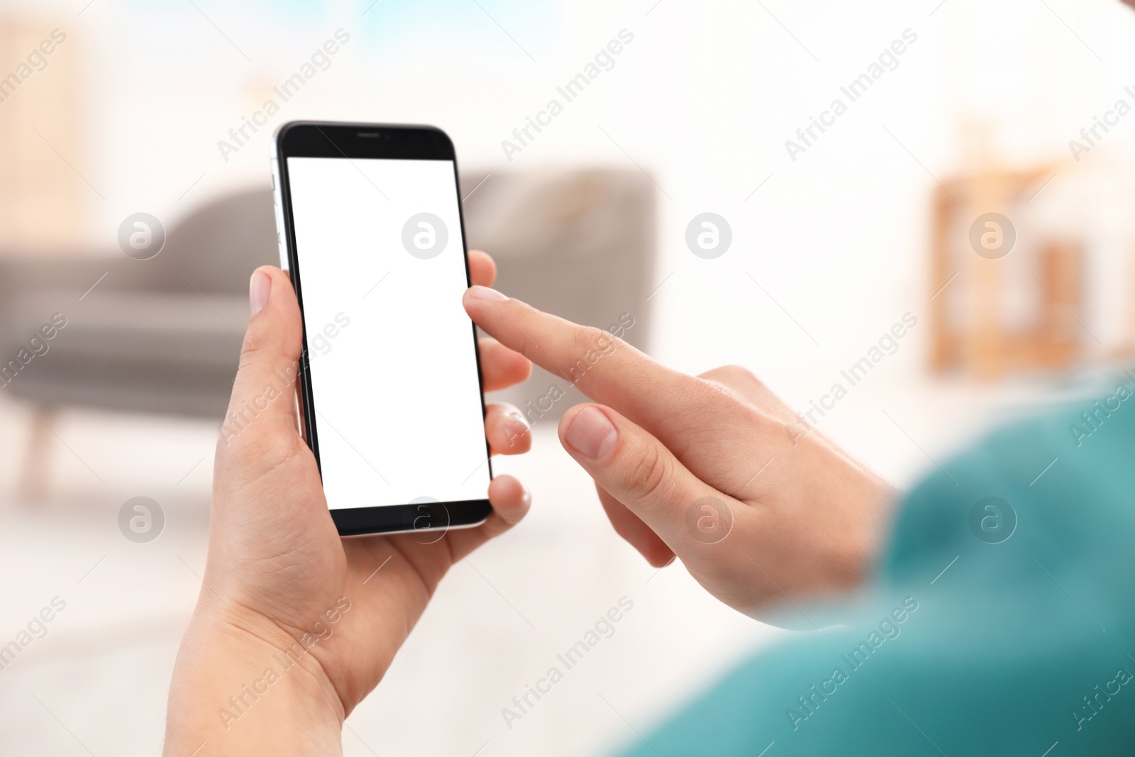 Photo of Man holding smartphone with blank screen indoors, closeup of hands. Space for text