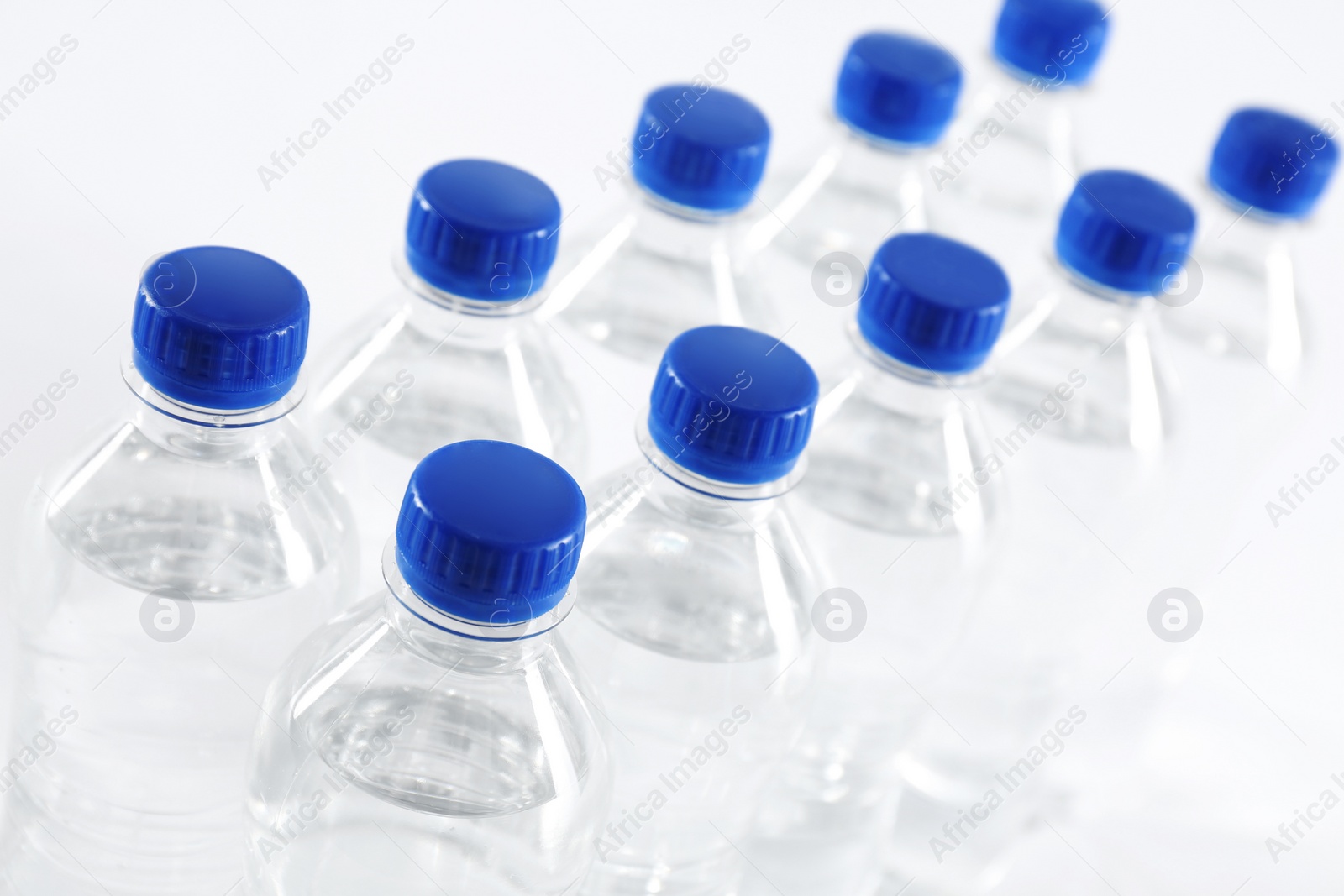 Photo of Plastic bottles with pure water on white background, closeup