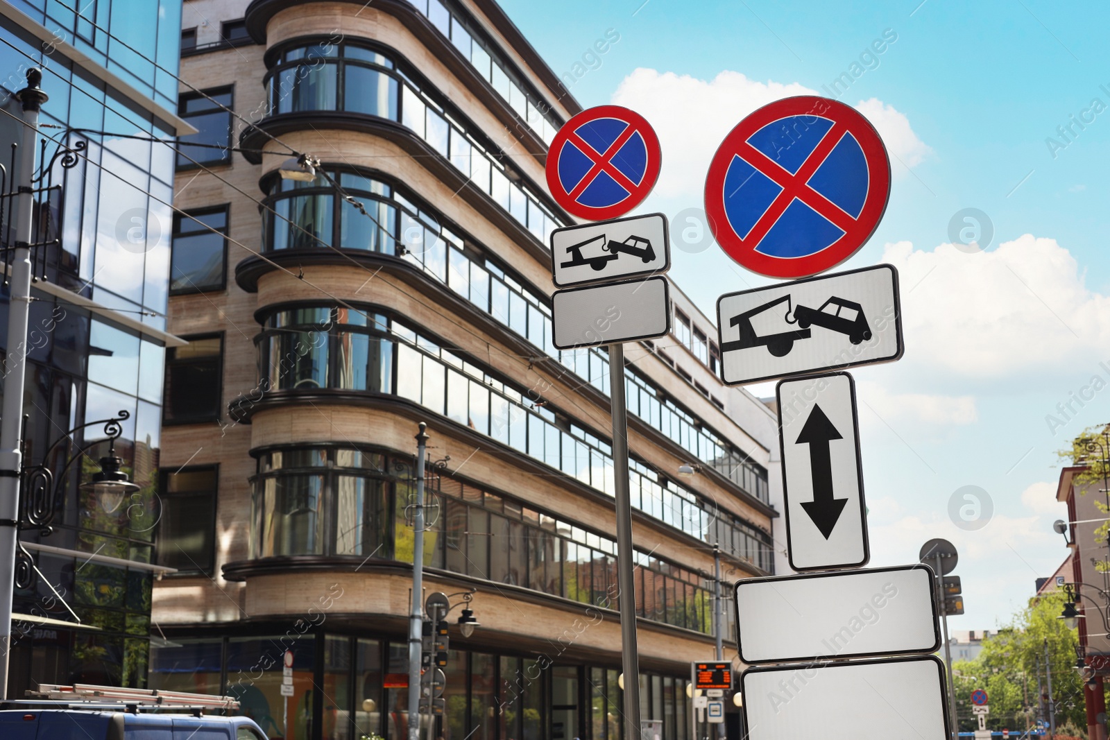 Photo of Posts with No stopping road signs and complementary plates on city street