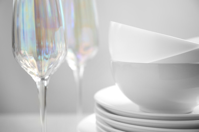 Photo of Set of clean dishes and glasses on table, closeup