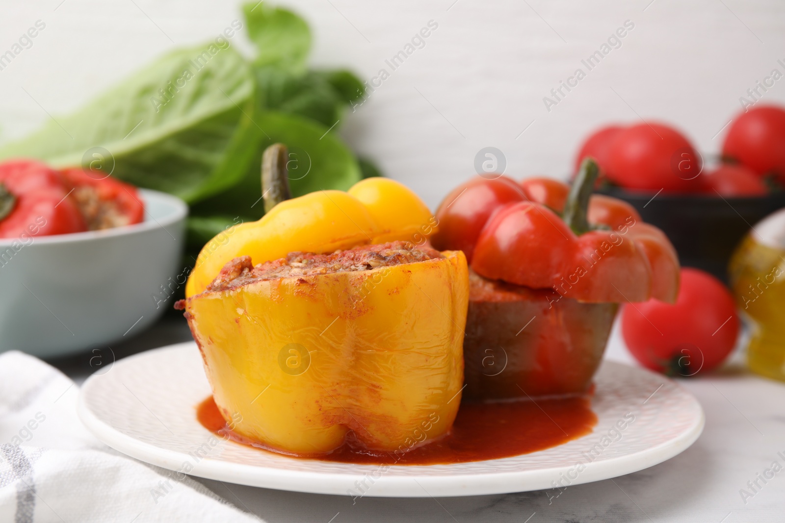 Photo of Delicious stuffed bell peppers served on white marble table