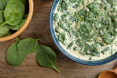 Photo of Tasty spinach dip on wooden table, flat lay