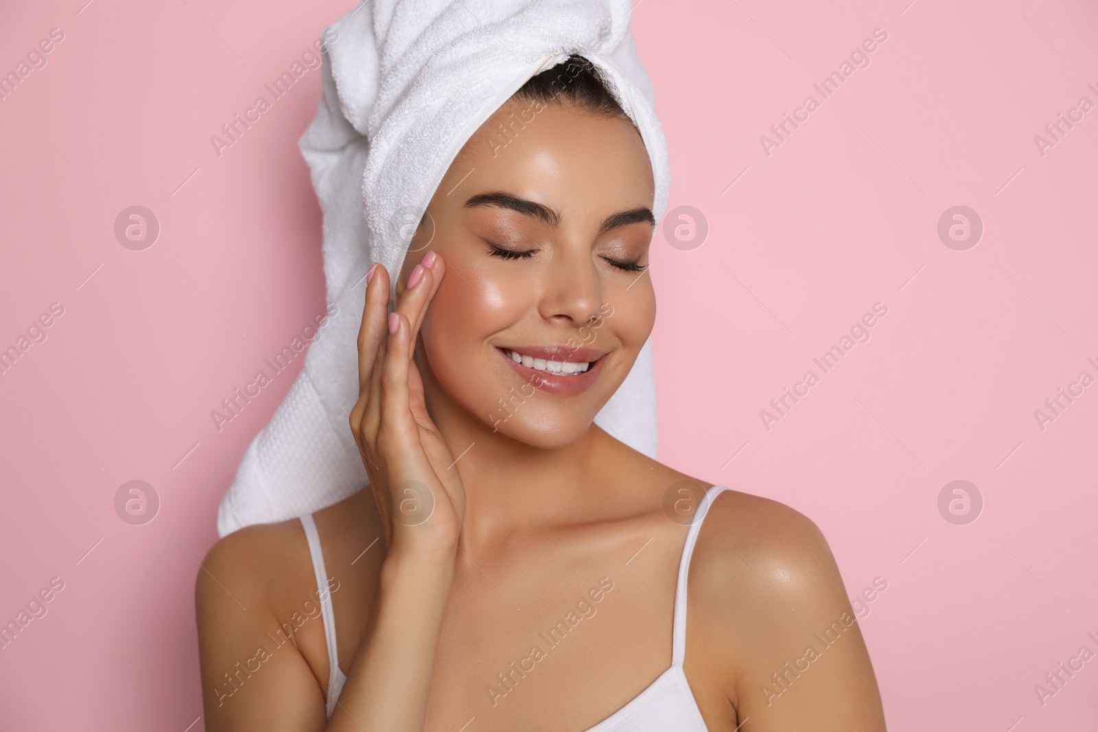 Photo of Beautiful young woman with towel on head against pink background