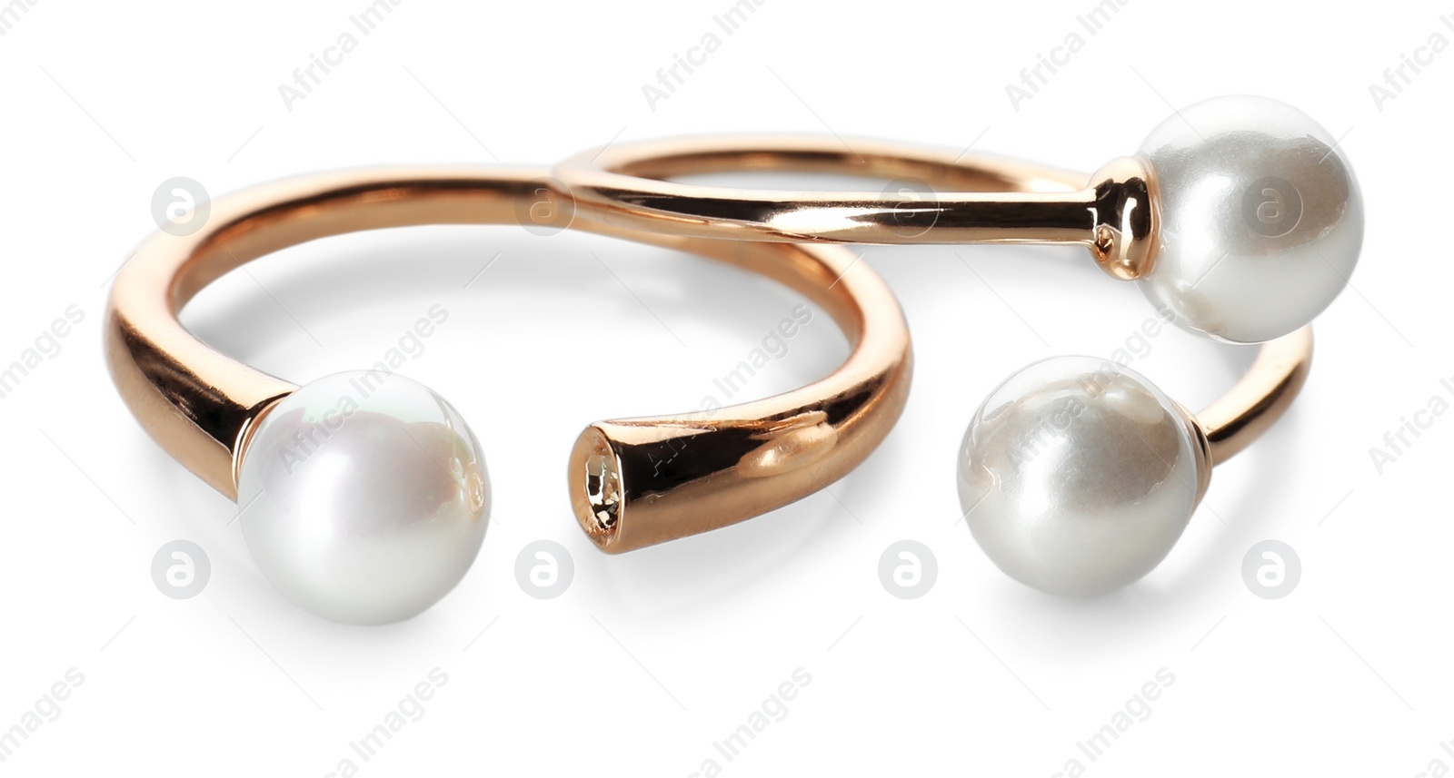 Photo of Elegant golden rings with pearls on white background