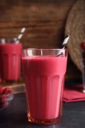 Photo of Tasty fresh milk shake on black table, closeup