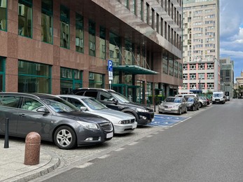 Photo of Different modern cars parked on city street