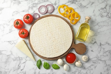 Photo of Flat lay composition with base and ingredients for pizza on marble table