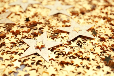 Golden confetti stars as background, closeup. Christmas celebration