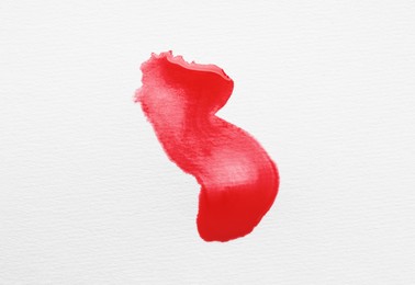 Photo of Blot of red ink on white background, top view