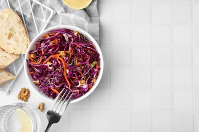 Tasty salad with red cabbage and walnuts on white tiled table, flat lay. Space for text