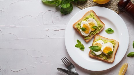 Photo of Tasty sandwiches with boiled egg, avocado and spinach served on white textured table, flat lay. Space for text