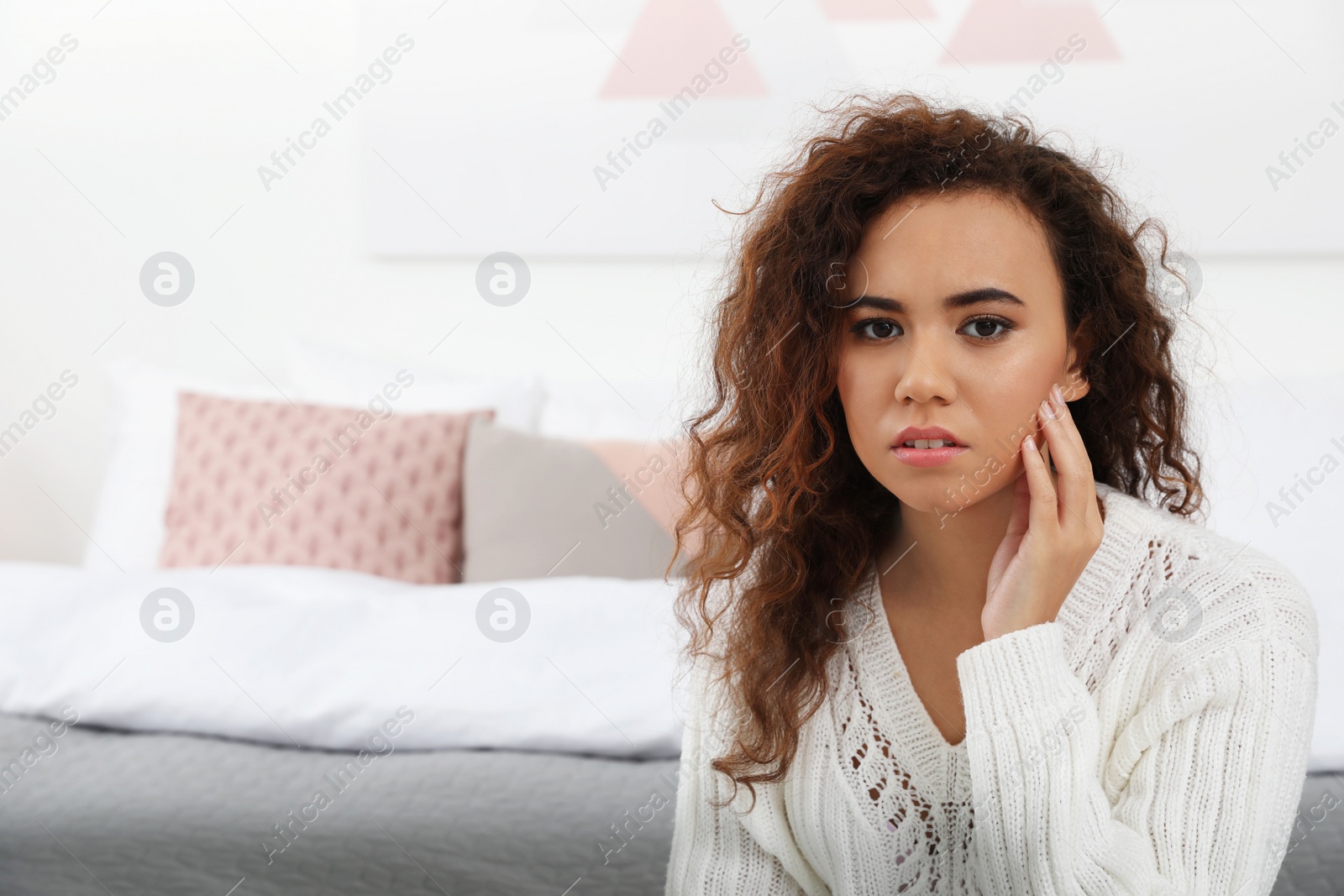 Photo of African-American woman suffering from tooth ache at home. Space for text