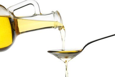Photo of Pouring cooking oil from jug into spoon on white background