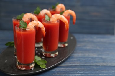 Photo of Shrimp cocktail with tomato sauce on blue wooden table