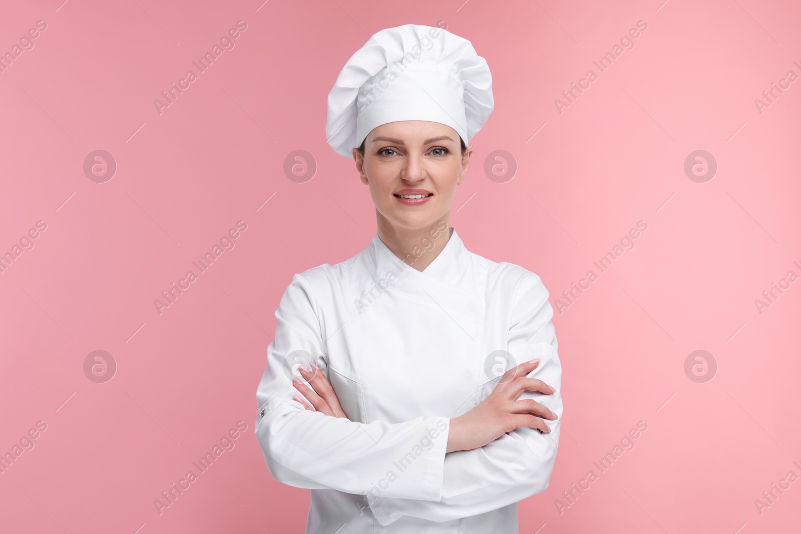 Photo of Happy woman chef in uniform on pink background