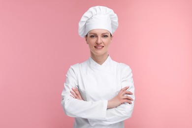 Photo of Happy woman chef in uniform on pink background