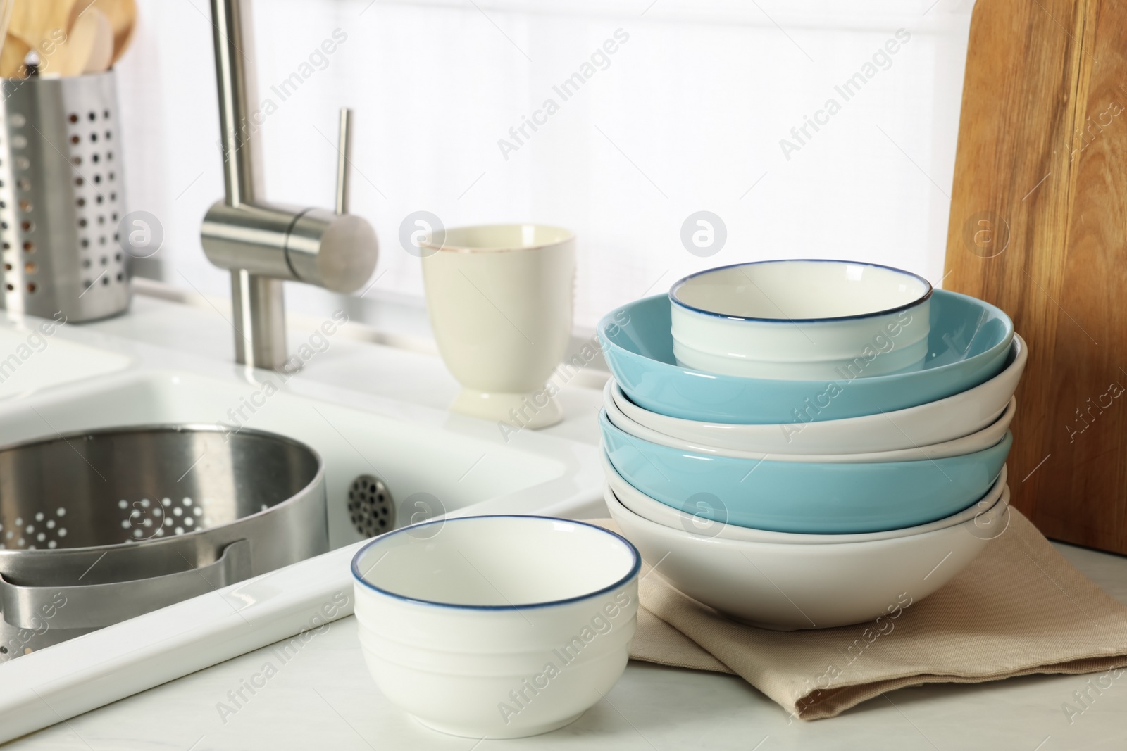 Photo of Bowls and different cooking utensils near sink in kitchen