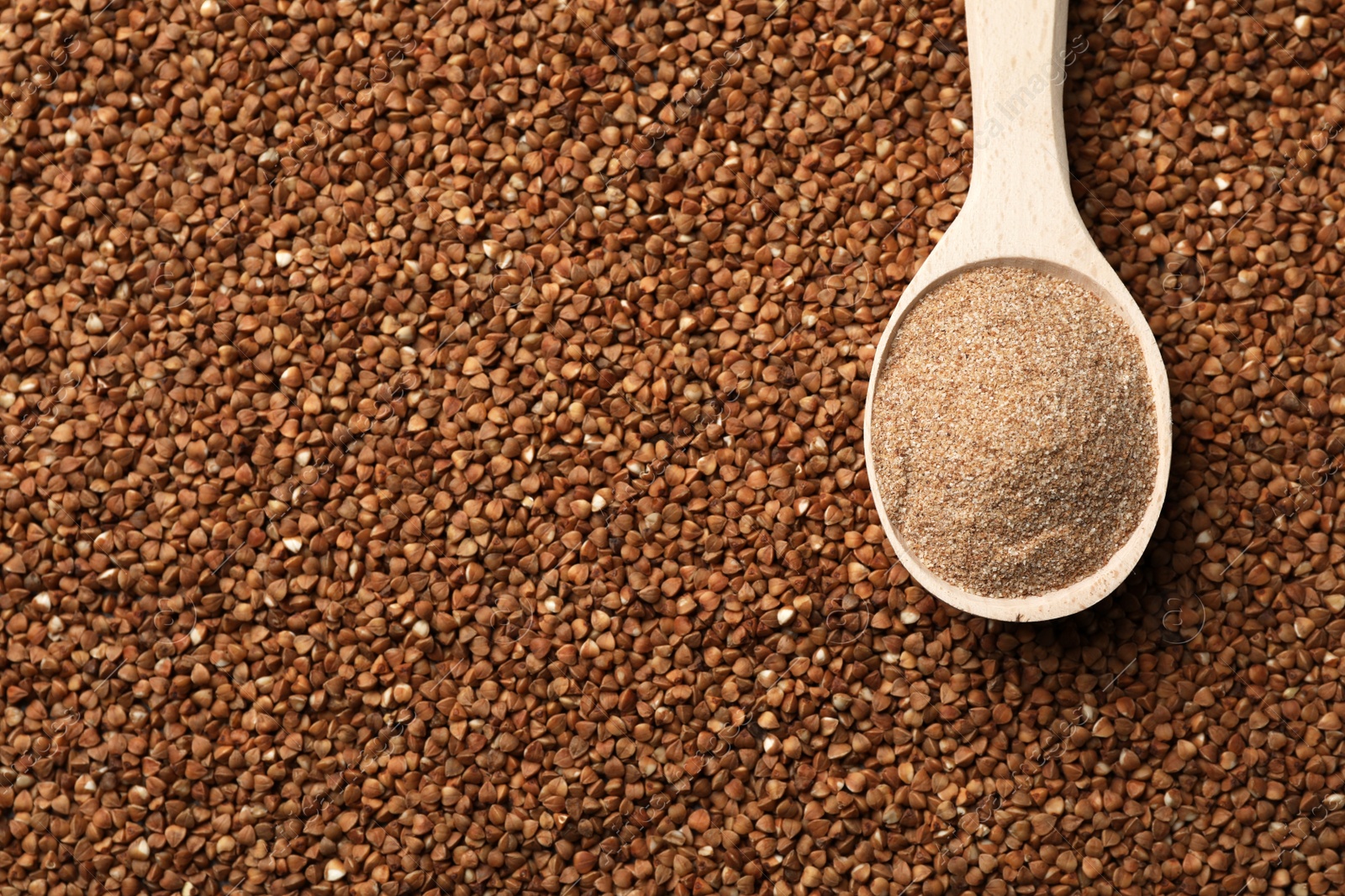 Photo of Spoon of gluten free flour on buckwheat, top view with space for text