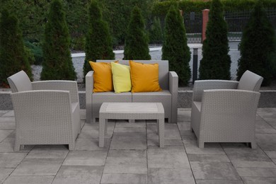 Photo of Beautiful rattan garden furniture and soft pillows outdoors